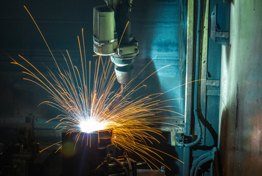 Motion Welding robots in a car factory with sparks, manufacturing, industry
