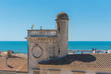      Saintes-Maries-de-la-Mer in Camargue, panorama of the town, tiles roofs, and the sea, view from the church

