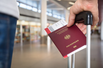 Person With Luggage Holding Passport And Boarding Pass Tickets