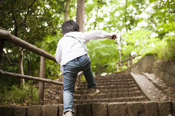 Naklejka na ściany i meble The boy climbing the stairs in the park