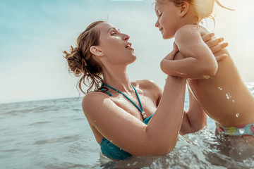 mutter lernt tochter im meer das schwimmen