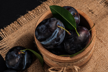 Garden plums in bowl on stone table. View with copy space