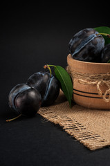 Garden plums in bowl on stone table. View with copy space