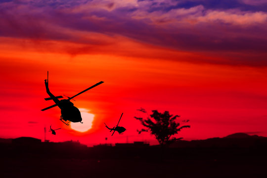 silhouette of helicopter on sunset with copy space add text ( Concept stop hostilities To peace)