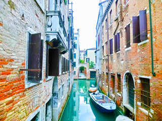 Fototapeta na wymiar Classical picture of the venetian canals with boats across canal
