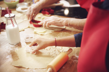 Close Up of human hand cutting cookies out
