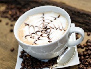 Good Morning: Close up white coffee cup  on wood tab / Cup of latte art coffee with coffee beans :) 