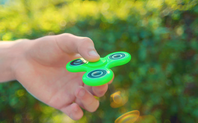 Young man hand holding  popular antistress gadget fidget spinner