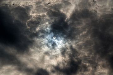 Sonne hinter dunklem Wolkenhimmel