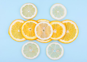 Obraz premium Fresh fruit in a cut on blue background. Pattern of citrus fruits. Diet and healthy food concept. Flat lay style.