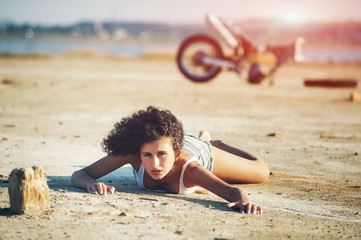 Girl lying on the ground .In the background a broken motorcycle .