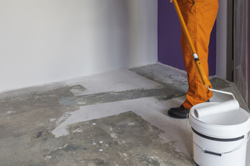 Interior of apartment under construction. Man holding a roller a