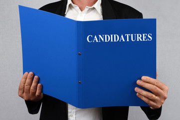 Homme consultant le dossier des candidatures 