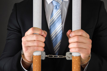 Handcuffed Businessman Holding Bars
