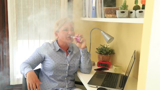 Portrait of  business woman  smoking electronic cigarette indoors