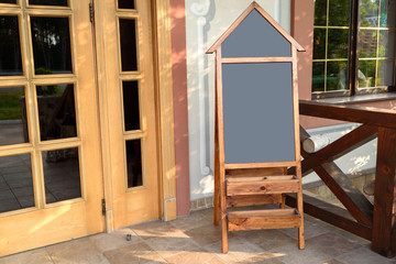 Large blank wooden chalkboard menu sign mockup outdoors, free space. Empty menu advertising blackboard near restaurant, copy space for text