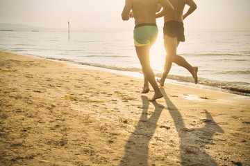Men running on the beach at sunset