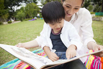 Mom and boy are reading a book together