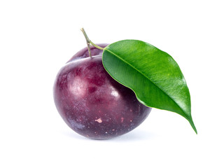 Pile of blue plums with green leaves over white background