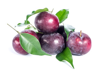 Pile of blue plums with green leaves over white background