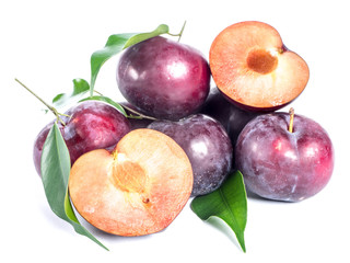 Pile of blue plums with green leaves over white background