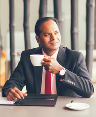 Thoughtful Business Man Drinking Coffee in Cafe