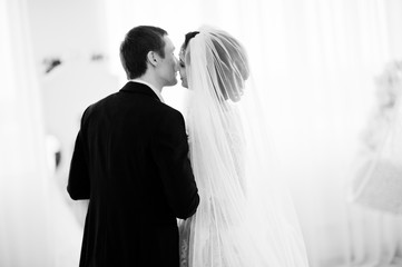 Gorgeous wedding couple enjoying each other's company in front of a mirror. Black and white photo.