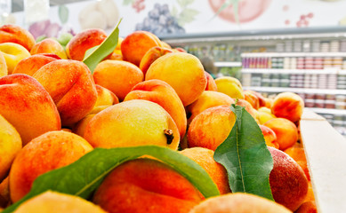 shelf at supermarket with ripe peaches