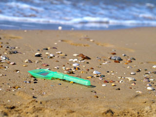 Fototapeta na wymiar toy plastic shovel left on beach, environment pollution