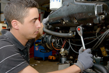 young man mechanic repairing  motor boats and other
