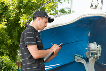 young mechanic checking the motor boat