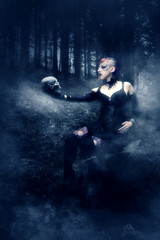 Mystische Frau mit Totenkopf im Wald