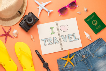 Summer traveling concept. Vacation accessories on orange background.