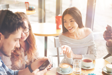 Positive international students resting in th cafe