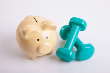 Green dumbbells with piggy bank for health insurance concept