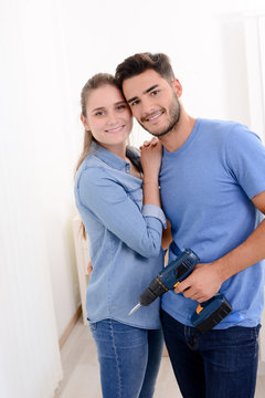 cheerful and happy young couple renovating and painting new home