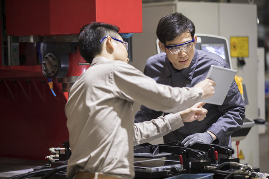 Confident engineers talking in the factory