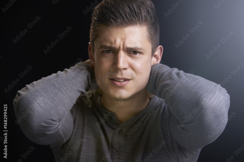 Sticker Portrait of angry young white man with hands behind his neck