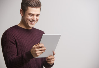 Smiling young white man holding a tablet computer
