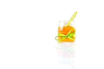 Glass jar with apricot jam isolated on white background.