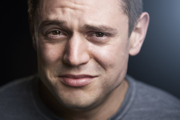 Close up portrait of upset young white man looking to camera