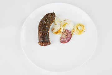 Grilled blood sausage on a white plate.