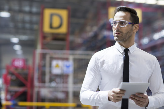 Businessman holding a digital tablet in the factory