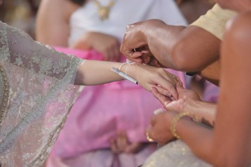 Obraz na płótnie Canvas Handfasting. Selective focus on hands of Thai wedding ceremony.