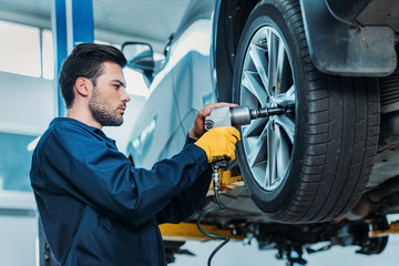 Automechanic unscrewing tire bolts