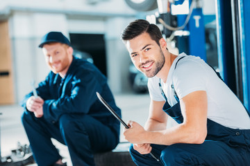 Automechanics sitting on floor