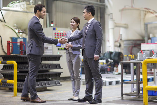 Business people shaking hands in the factory