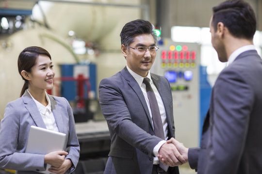 Business people shaking hands in the factory