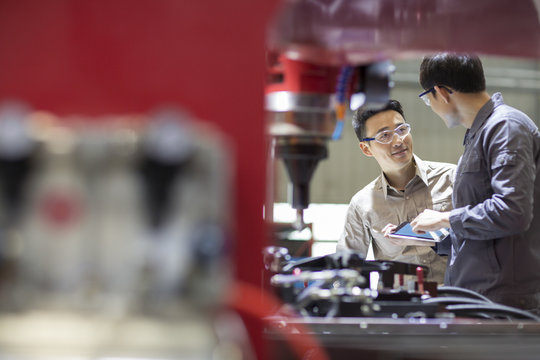 Young engineers talking in the factory