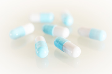 Pharmacy theme. Blue and White Isolated Capsules on the White Surface. Closeup.
